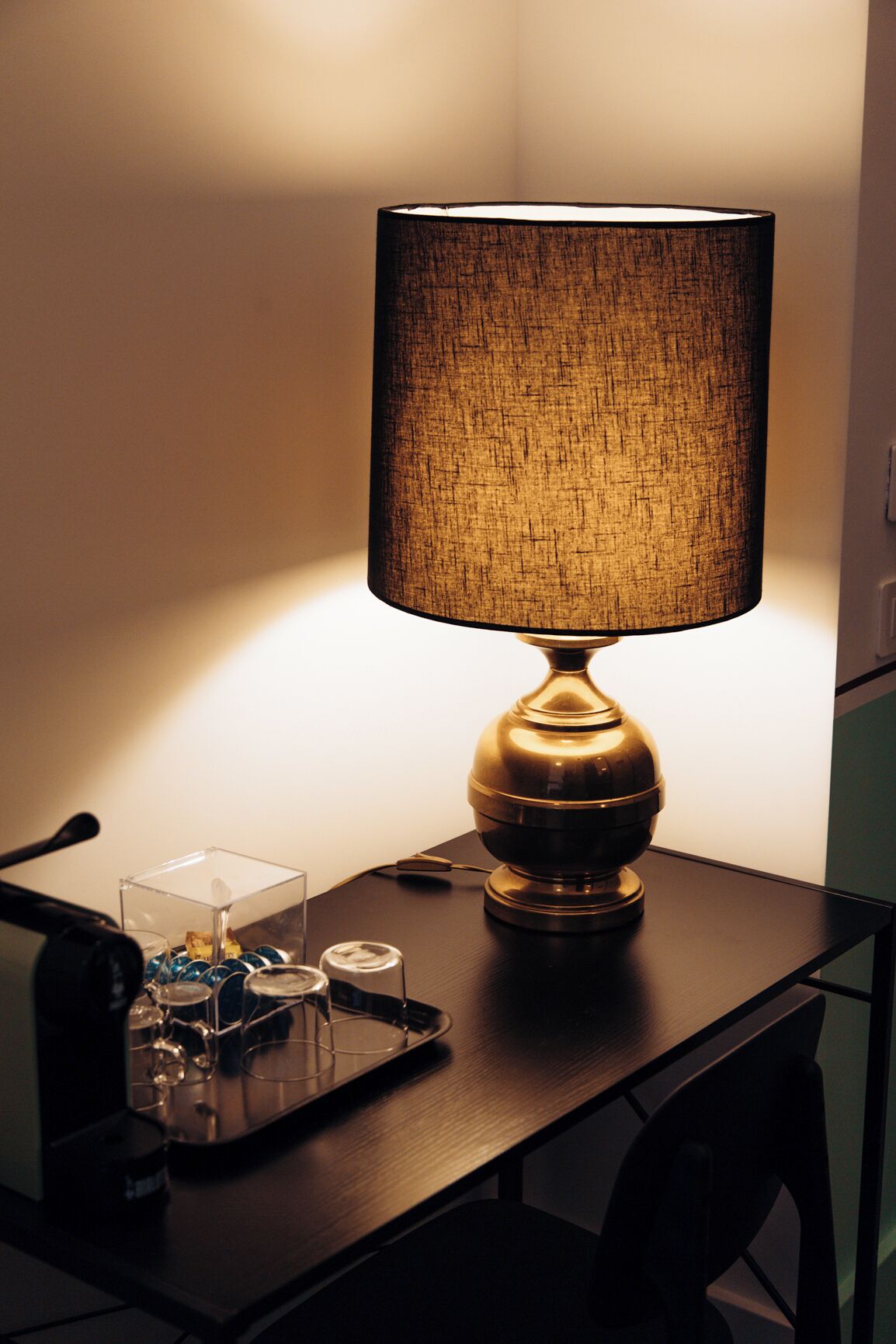 Ein Tisch mit einer Lampe, einem Glasbehälter und einer Metallschüssel.