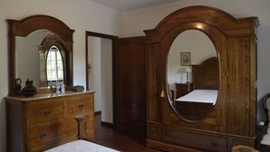 A traditional bedroom with a wooden dresser, a large mirror, and a bed. - Quinta de Maiores (Ovil)