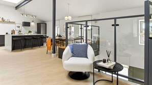 A modern living space with a kitchen, dining area, and a glass-enclosed balcony. - The Warehouse, Clifden Modern and elegant (Clifden)