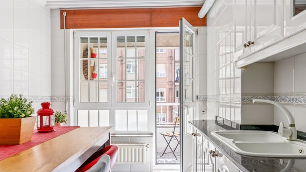 A modern kitchen with white cabinets, a wooden countertop, and a red lantern. - Apartment 'O Faro Apartamentos' with Sea View, Balcony and Air Conditioning (Ribadeo)