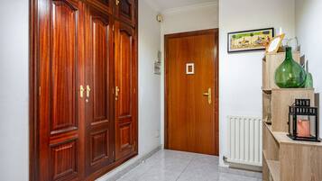 A hallway with wooden doors, a radiator, and a framed picture on the wall.
