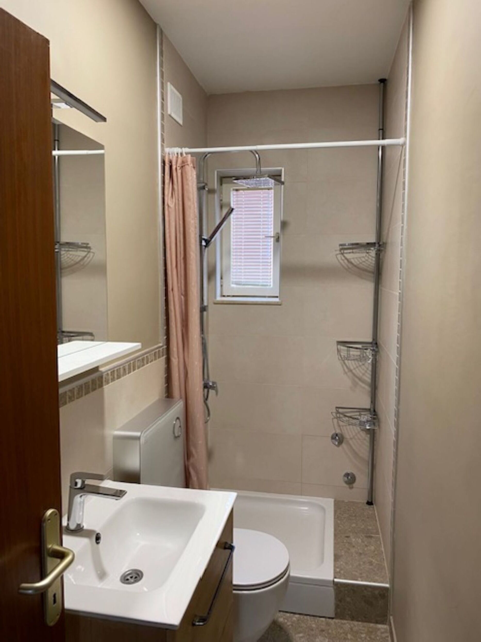A compact bathroom with a shower, toilet, and sink.