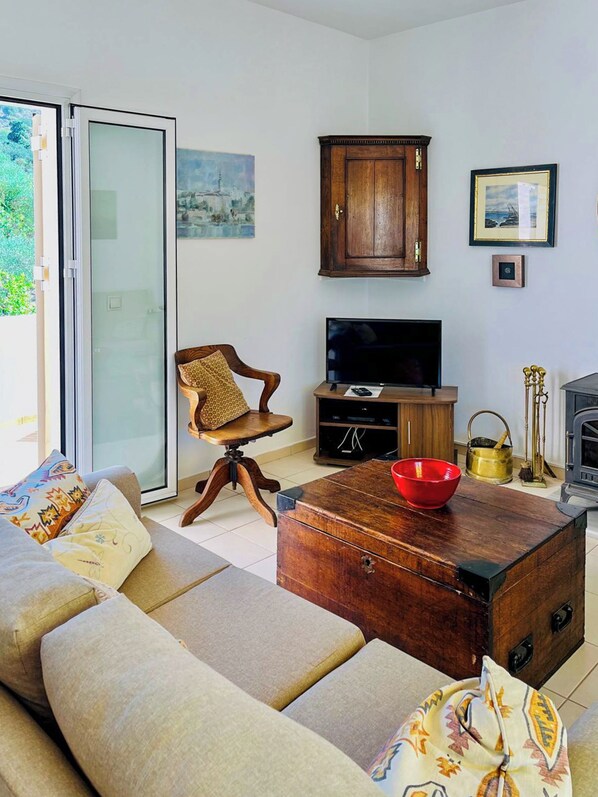 Un salon comprenant un canapé, une table basse en bois, un téléviseur et un meuble.