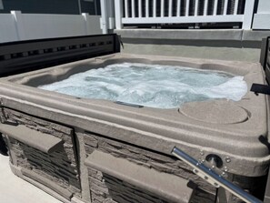 Un bain à remous avec une structure extérieure en pierre et un cadre en métal.