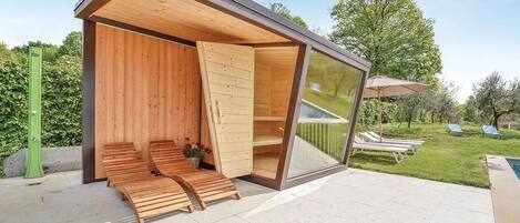 Un espace de détente extérieur moderne, doté de bancs en bois et d'une structure en verre.