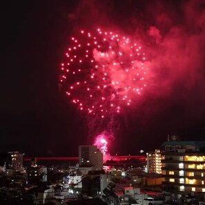 Un paisaje urbano con edificios y un espectáculo de fuegos artificiales en forma de corazón.