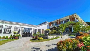 A modern building with a central courtyard, large windows, and a variety of plants. - Alta Terra Hotel Tagaytay (Tagaytay)