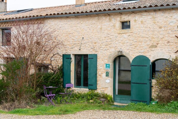 A stone building with a door, windows, and a small sign.