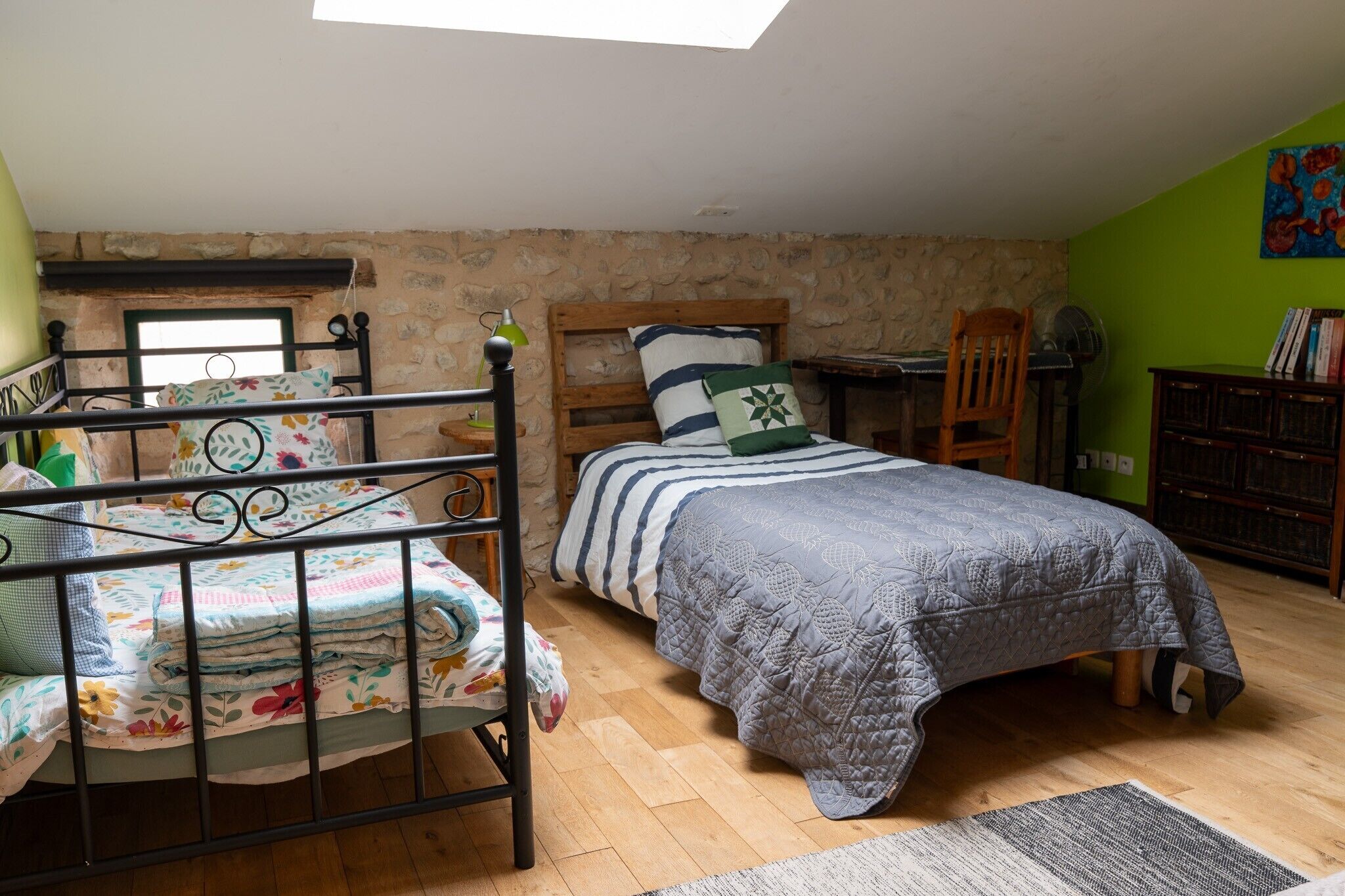 A bedroom with a bunk bed, a desk, a chair, and a bookshelf.