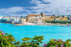 A coastal town with a historic building, a beach, and clear blue waters. - Tenuta Apollonio Pool & Relax (Carpignano Salentino)