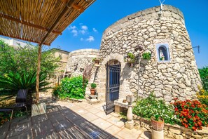 A stone building with a round tower, a covered patio area, and potted plants. - Tenuta Apollonio Pool & Relax (Carpignano Salentino)