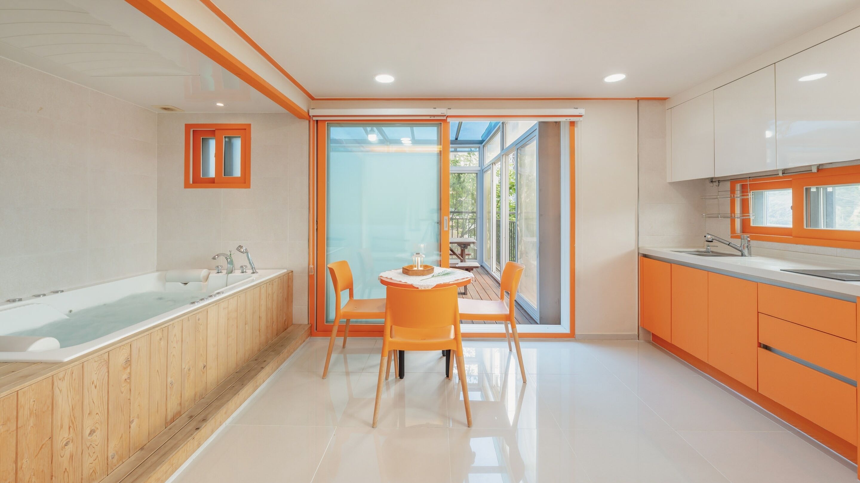 Une salle de bain moderne avec une baignoire, un lavabo et une table avec des chaises.