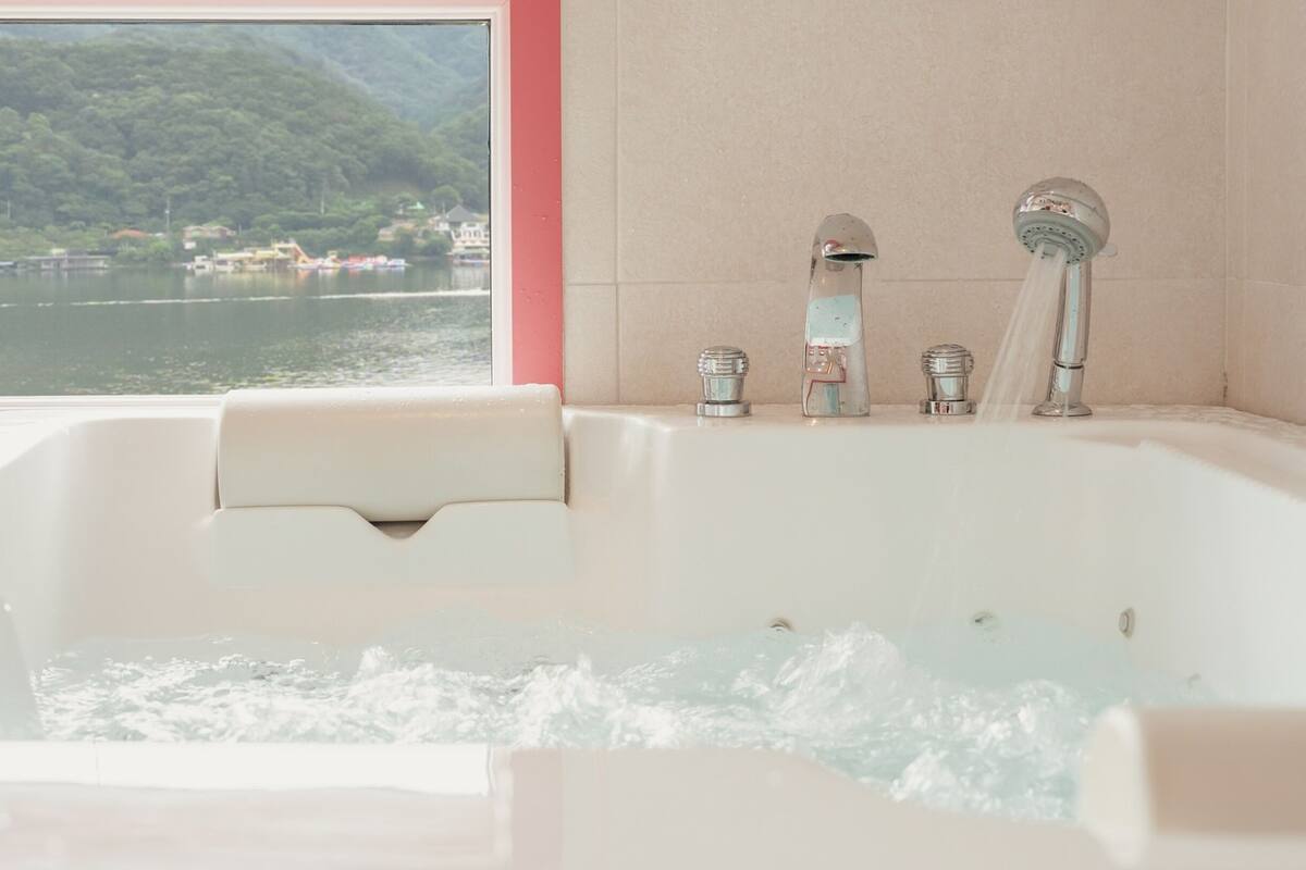 Eine Badewanne mit Blick auf einen See und Berge.
