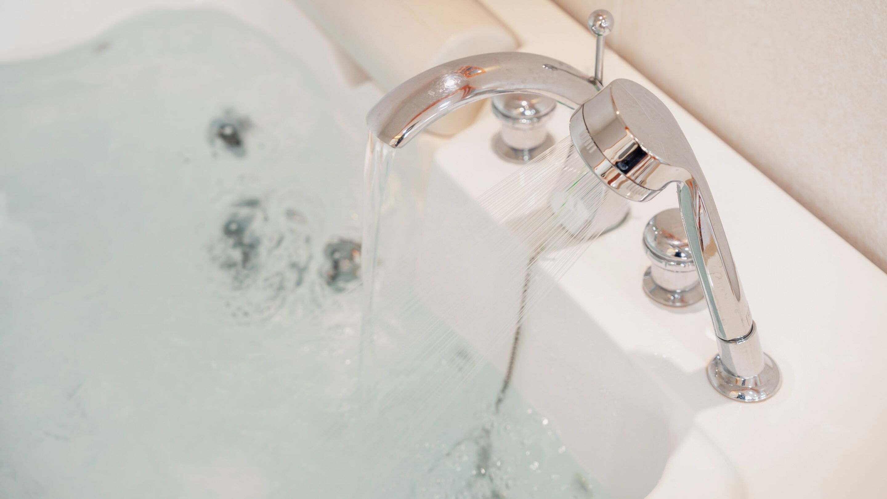 Ein Badezimmer mit einem modernen Wasserhahn und klarem, fließendem Wasser.