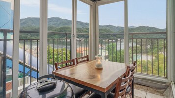 A balcony with a table and chairs, a kettle, and a table lamp.
