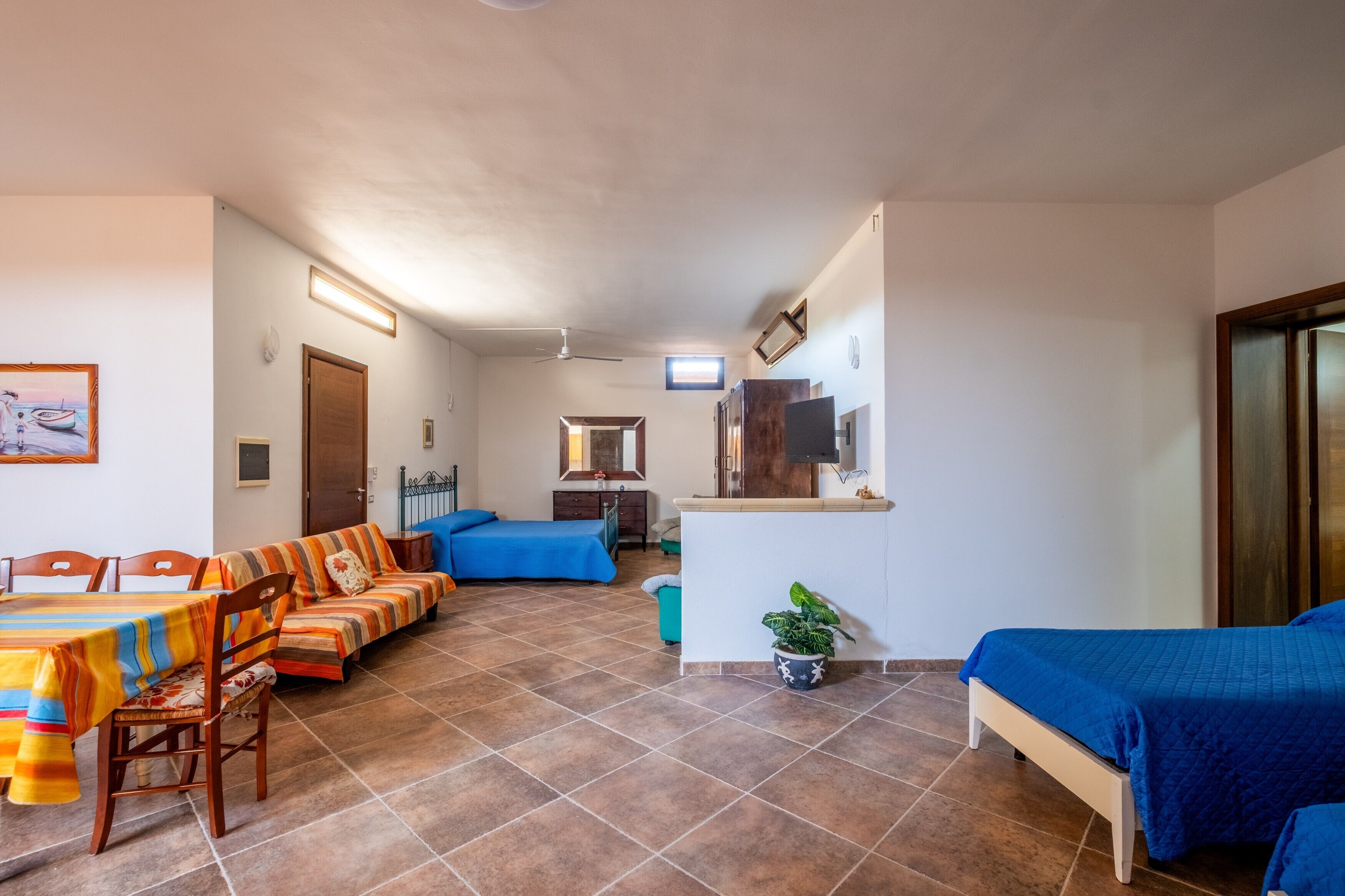 Una habitación con una mesa de comedor, sofá y kitchenette.