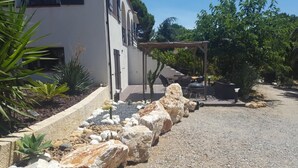 A modern house with a patio area, outdoor seating, and a pergola. - 5 mns from the sea and 10 mns from Perpignan by car, 2-room apartment in the heart of nature. (Canet-en-Roussillon)
