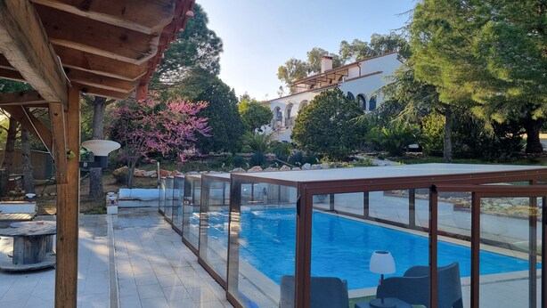 A swimming pool with glass railings, outdoor furniture, and a pergola structure. - 5 mns from the sea and 10 mns from Perpignan by car, 2-room apartment in the heart of nature. (Canet-en-Roussillon)