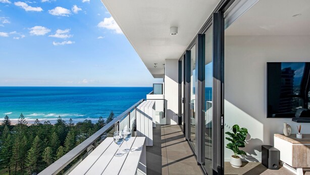 Un balcon avec vue sur l’océan, une plante en pot et un haut-parleur.