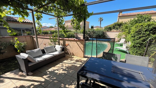 A patio with a sofa, a table, and a pool. - Villa Piscine 6 People (Corneilla-del-Vercol)