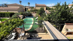 A residential area with a swimming pool, lounge chairs, and a view of neighboring houses. - Villa Piscine 6 People (Corneilla-del-Vercol)