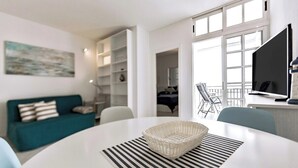 Una sala de estar moderna con una mesa blanca, un sofá azul aguamarina y un amplio ventanal.
