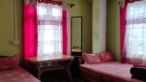 A room with two beds, a wooden desk, and a mirror. - Bhagirath Homestay (Mirik)