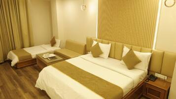 Habitación de hotel con una cama grande, una cama más pequeña, una mesita de noche con teléfono y un ventilador de techo.