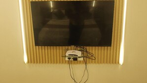Un televisor de pantalla plana colocado en una pared con listones de madera verticales.