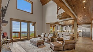 A spacious living area with a large window, a fireplace, and a view of the outdoors.