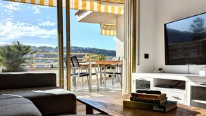 A modern living room with a sofa, a TV, and a table with books.