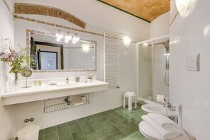 A bathroom with a white sink, mirror, and green-tiled floor. - Relaxing Family Podere Delle Rose Pool & Garden (Civitella Paganico)