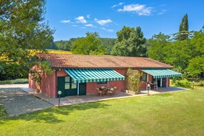 A house with a tiled roof, a covered patio, and a lawn. - Relaxing Family Podere Delle Rose Pool & Garden (Civitella Paganico)
