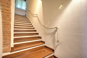 Un escalier avec des marches en bois et une barrière faite de cordes.