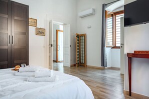 A hotel room with a bed, a wooden wardrobe, a television, and a window with curtains. - Giosue' Apartment Near Bari (Adelfia)