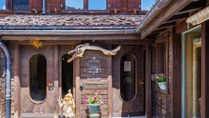 A wooden building with a rustic entrance, a statue, and a sign indicating it is a hotel with wellness and spa services. - Lovely apartment in villa for 15 guests with WIFI, hot tub and terrace (Vercorin)