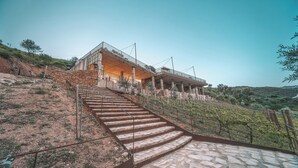Un edificio con una escalera de piedra que lleva a un espacio al aire libre cubierto con un balcón.