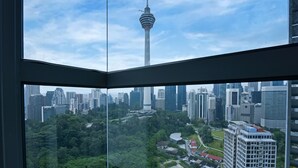 Vista panorámica de un paisaje urbano con una torre destacada, abundante vegetación y edificios modernos.