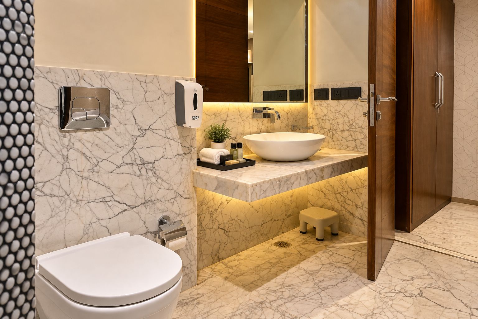 Ein modernes Badezimmer mit Toilette, Waschbecken mit Marmorplatte, einer Seifenspender und einem kleinen Hocker.