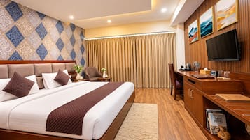 Una habitación de hotel con una cama grande, un escritorio con una televisión de pantalla plana, una estantería con libros de viajes y una pared con diseño.