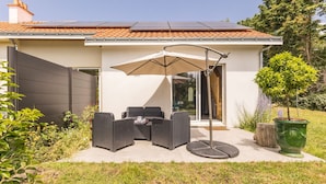 A modern house with a patio, outdoor furniture, and a green planter. - Quiet cottage near Pornic with wifi, pets welcome (Chauve)