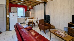 Ein gemütliches Wohnzimmer mit einem roten Ledersofa, einem Holztisch und einem Kamin.