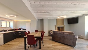 Una cocina moderna con comedor, suelo de madera y una chimenea empotrada.