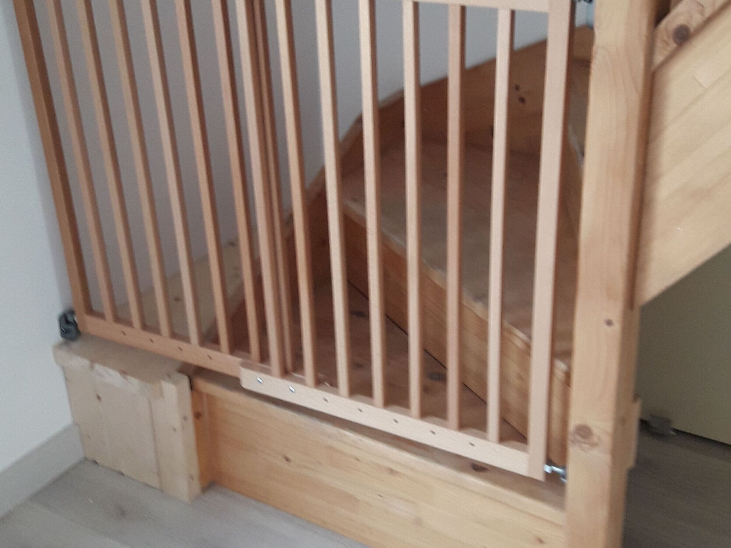 Un escalier en bois avec une rampe en métal.
