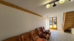 A spacious room with a wooden ceiling, a large window, and a wooden staircase. - Independent House with Garden in South Berry (Crozon-sur-Vauvre)
