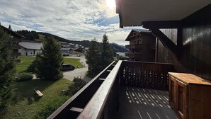 Een balkon met uitzicht op een dorp en bergen.