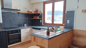 Una cocina moderna con lavavajillas, horno y ventana con vistas a la ciudad.