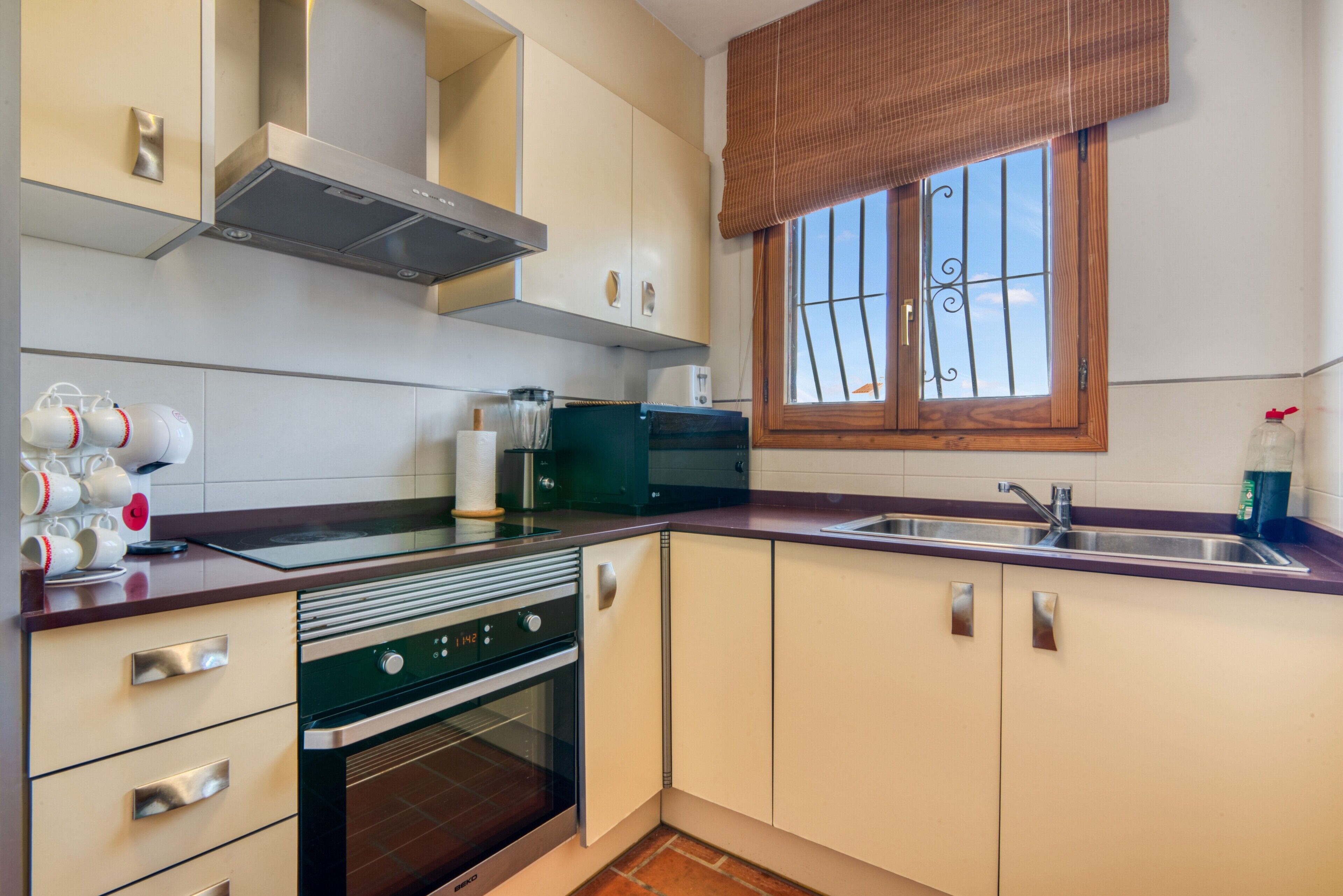 Une cuisine équipée d’une cuisinière, d’un four, d’un four à micro-ondes et d’une fenêtre donnant sur un beau paysage.