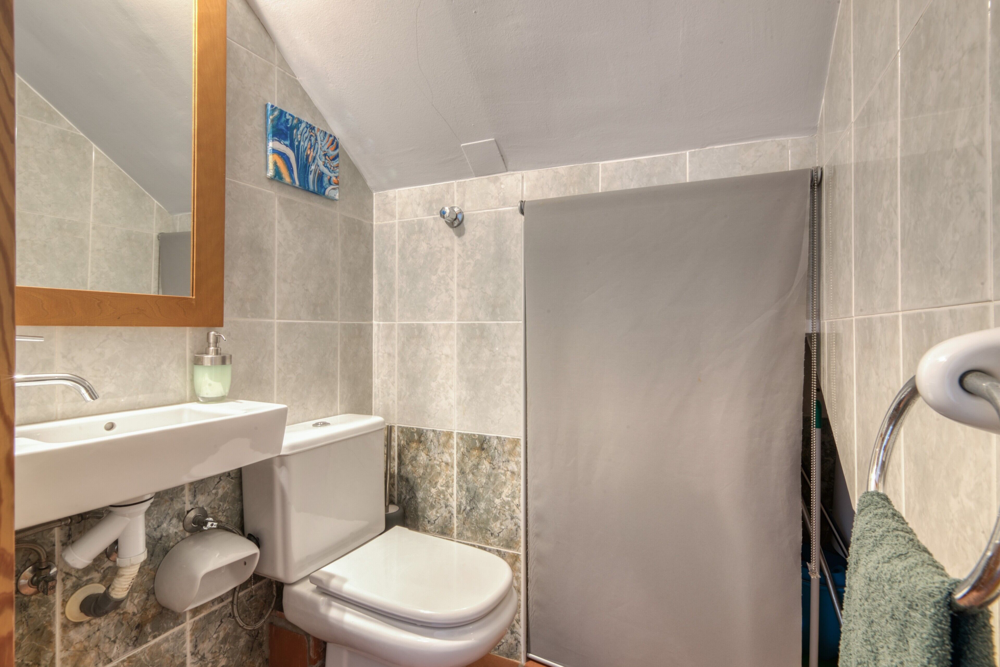A bathroom with a sink, toilet, and shower area.