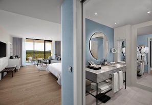 A modern hotel room with a large bed, a desk, a bathroom with a mirror and sink, and a view of the outdoors. - Akra Didim Resort & SPA (Didim)